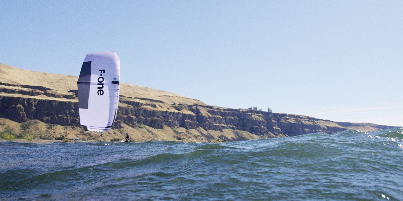 F-ONE Kite zieht einen Rider vor goldener Steilküste